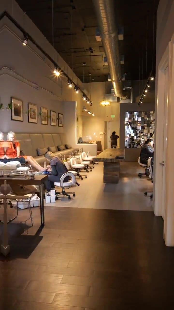 Pedicure chairs along the stone wall inside Gloss Nail Bar